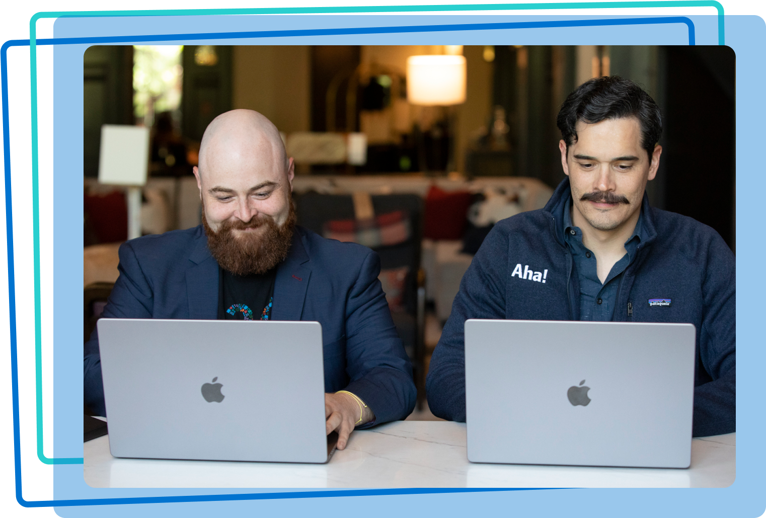 Two men working together on laptops
