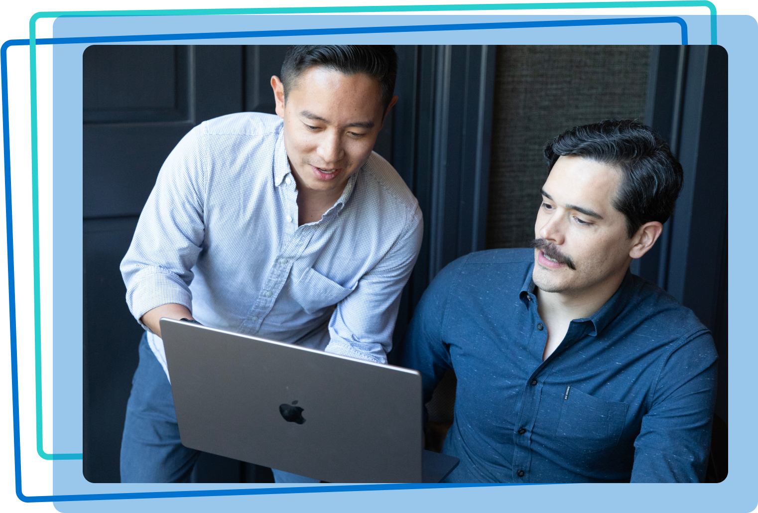 Two men working together on a laptop