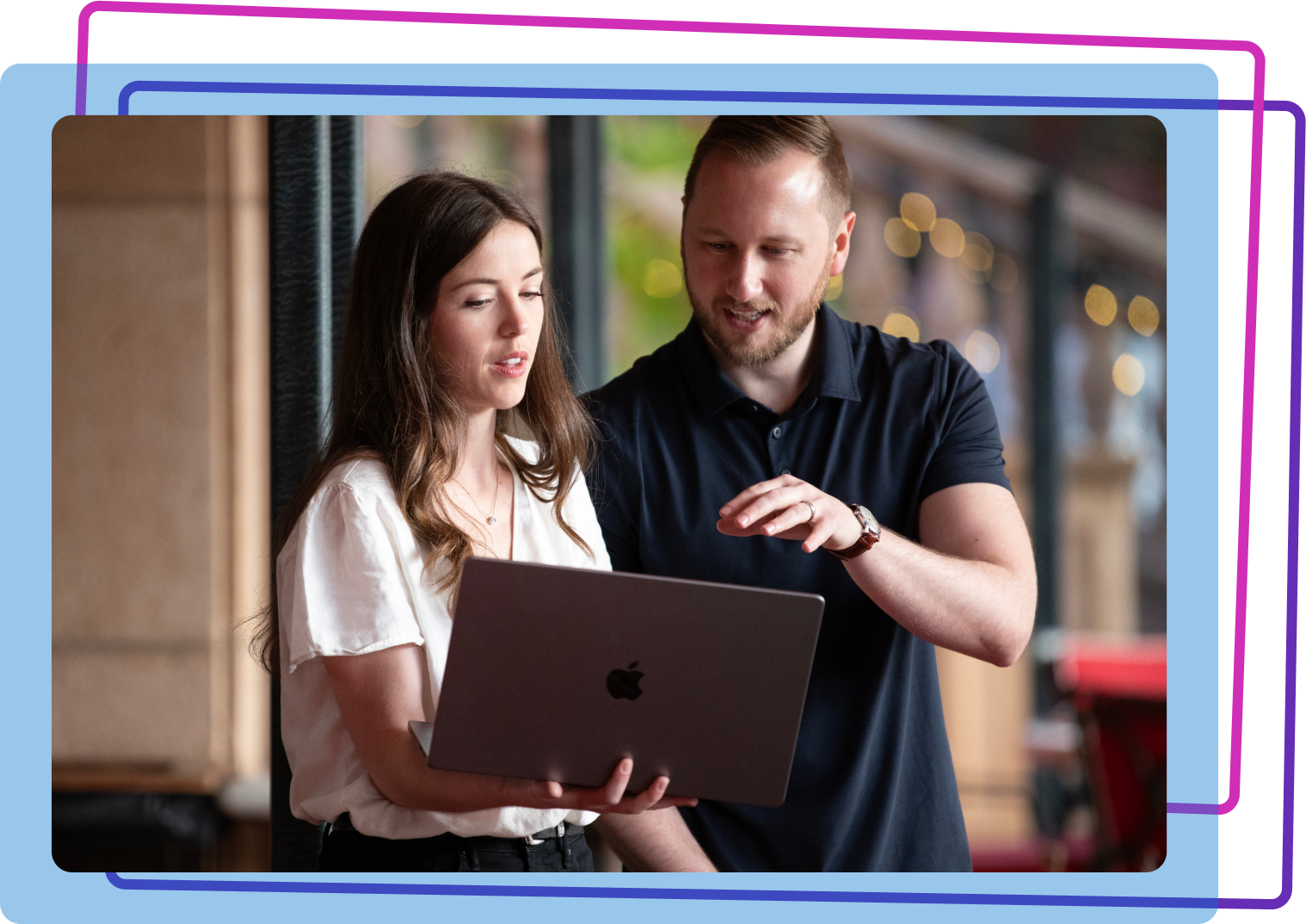 A man and women standing together looking at a laptop